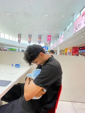 Issa hugging a plushie in a food court